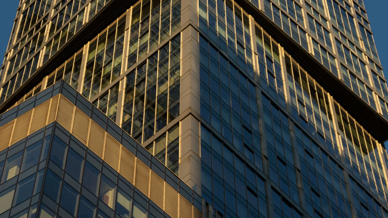 Glas-Hochhaus in goldenem und blauem Abendlicht