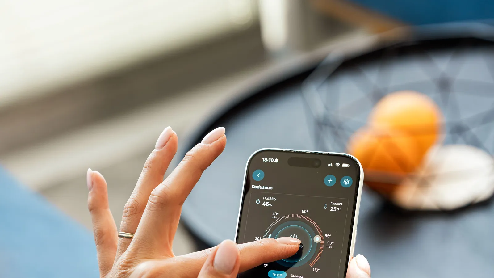 Hand holding a smartphone with a dark smart home app