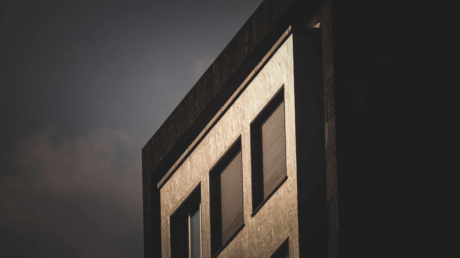 Dark office facade at night with single lit windows