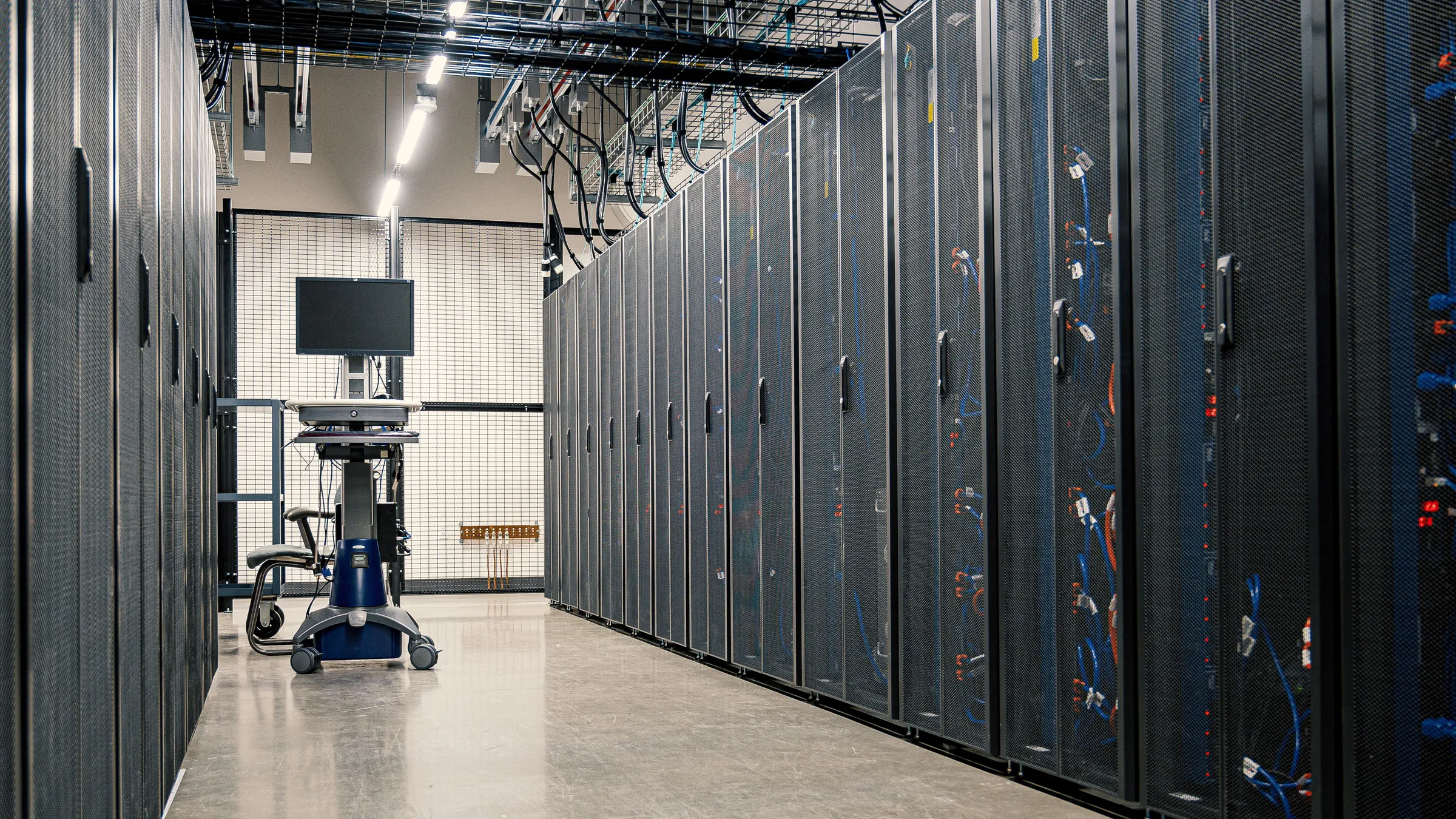 Server aisle in a data center with a mobile workstation between rack rows