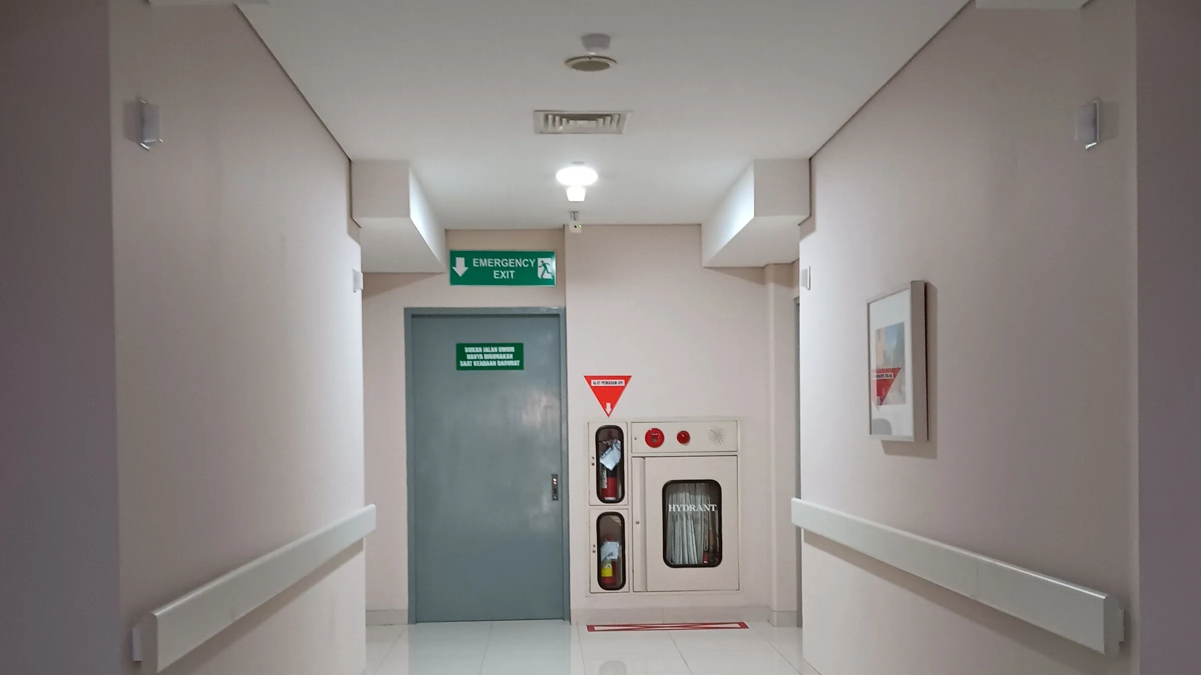 Klinikflur mit Notausgang-Beschilderung und Brandschutzausstattung
